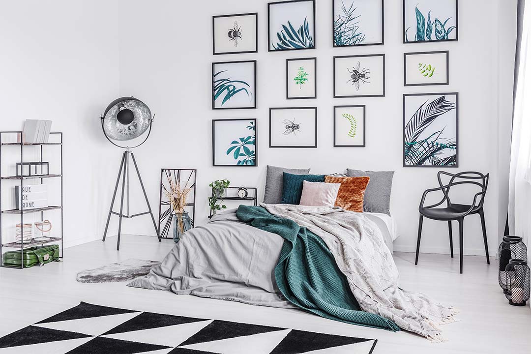 Real photo of a bed with cushions and a blanket standing in a mo